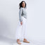 Woman wearing the Balboa Sneaker in blush nubuck, styled with white flowy pants and a light blue sweater