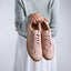 Person holding a pair of Balboa Sneakers in Blush nubuck