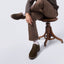 Man sitting on a stool wearing the Featherlight Founder