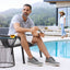 Man sitting by a pool wearing Featherlight Muir Gray Nubuck shoes, with a woman in the background.