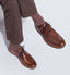 Model with legs crossed wearing Men's Founder Oxford in Cognac.