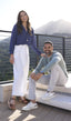 Man and woman sitting on a rooftop deck with a scenic view wearing Samuel Hubbard shoes.