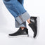 On model shot of the Laguna Zip Bootie in Black leather paired with cuffed jeans. 