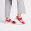 Portola Two-Strap Fuchsia Nubuck sandal worn with gray pants on a white background