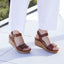 Portola Two-Strap Wedge Cognac Leather worn with white pants on a light surface