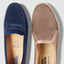 Navy loafer and rose gold slip-on shoe with brand name on soles against a light gray background